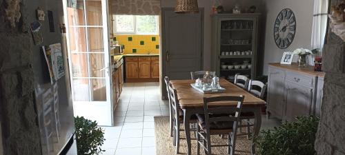 une cuisine avec une table et des chaises en bois dans l'établissement Chambre - Saint-jean d'ataux, à Laveyssière