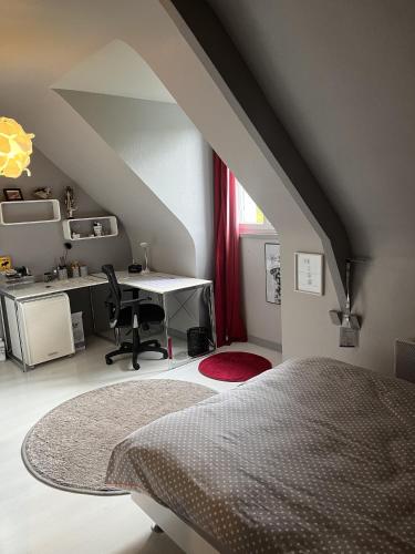 Cette chambre mansardée comprend un lit et un bureau. dans l'établissement Chez Charly, à Pruillé-le-Chétif