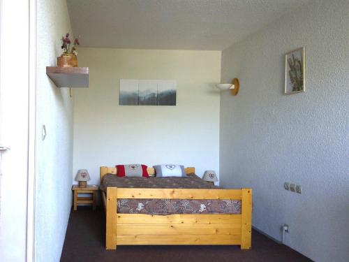 a bedroom with a wooden bed in a room at Appartement cosy 2 pièces pour 6 personnes à Arc 1600, proche des pistes - FR-1-411-337 in Bourg-Saint-Maurice