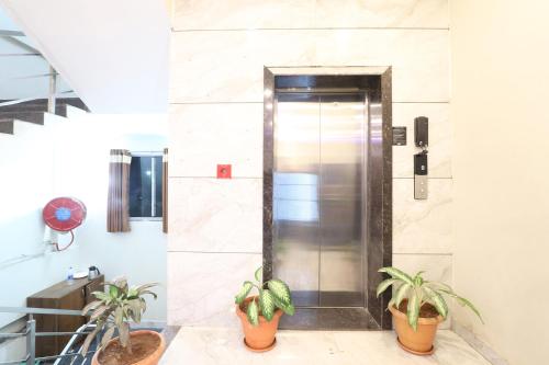a elevator in a building with two potted plants at FabHotel Simhadri Grand-Nr Khammam Railway Station in Khammam