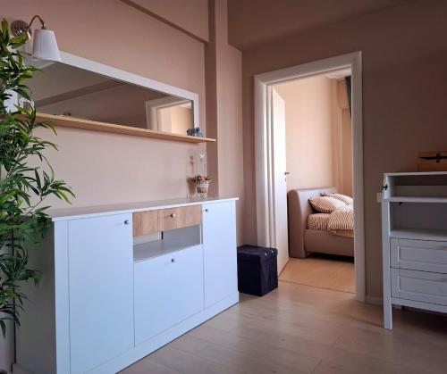 a room with a white cabinet and a mirror at Homey Apartment Vacaresti in Bucharest