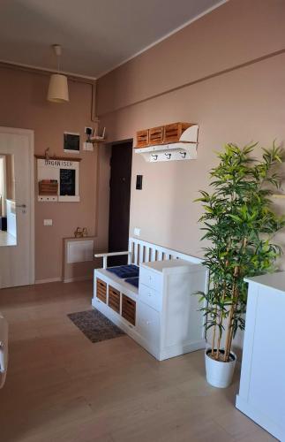 a room with a bed and a potted plant at Homey Apartment Vacaresti in Bucharest