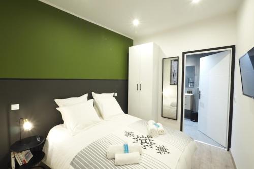 - une chambre avec un grand lit blanc et un mur vert dans l'établissement 06R - Nice modern apartment - Vieux Nice, à Nice