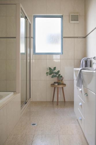 a bathroom with a shower and a sink and a window at Waves for Daze in Middleton