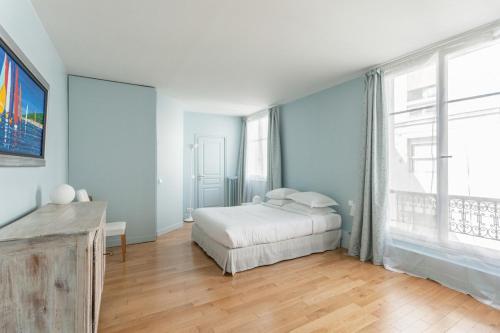 une chambre avec un lit et une grande fenêtre dans l'établissement The Azure Pearl -Spacious & Modern, à Paris