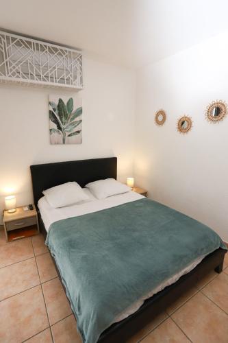 une chambre avec un grand lit avec une couverture verte dans l'établissement Grand studio 5 pour 2 a 4 p, à Argelès-sur-Mer