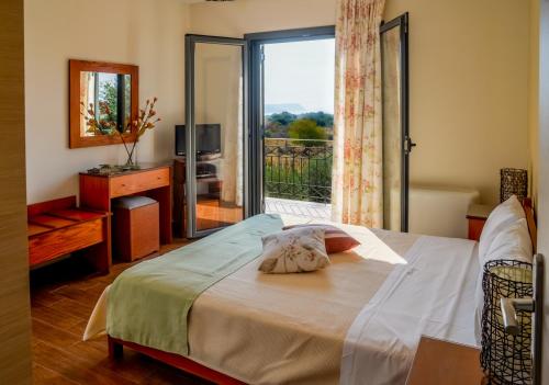 um quarto com uma cama e uma janela com uma varanda em Korallis Villas em Karavádhos