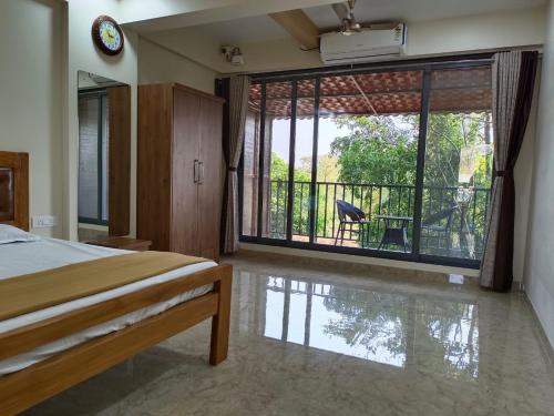 a bedroom with a bed and a view of a balcony at Arav Resort in Katrab