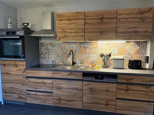 a kitchen with wooden cabinets and a sink at Lindenhof Habernis in Steinberg