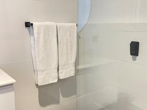 a bathroom with white towels hanging from a shower at Serene Haven in Sanctuary Point in Sanctuary Point