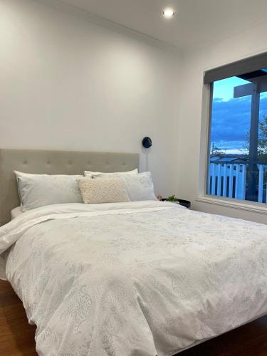 a bedroom with a large white bed with a window at Serene Haven in Sanctuary Point in Sanctuary Point