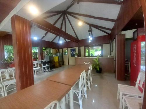 a dining room with a long table and white chairs at Casa Felicisima Inn in Puerto Princesa City