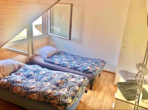 two beds sitting in a room with a window at Lavaux nice place in Swiss French part in Rivaz