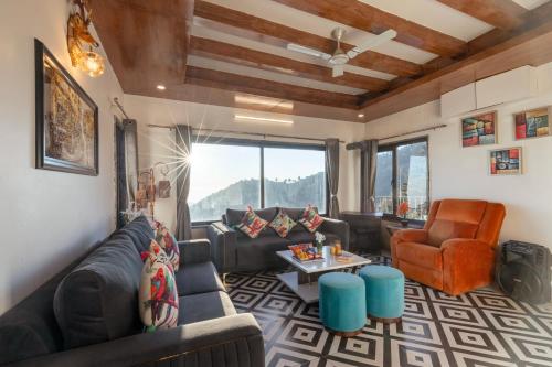 un salon avec un canapé et une table dans l'établissement Alaya Stays Evara - 2 BHK Hilltop Hideaway With Balcony, Fireplace & Scenic Views, à Mussoorie