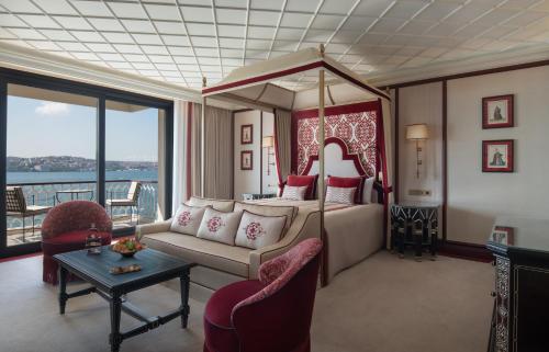 a hotel room with a bed and a couch and a table at Çırağan Palace Kempinski Istanbul in Istanbul