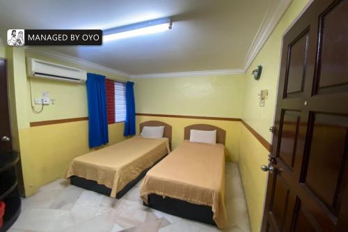 Ένα ή περισσότερα κρεβάτια σε δωμάτιο στο Hotel O Lumut Villa Inn