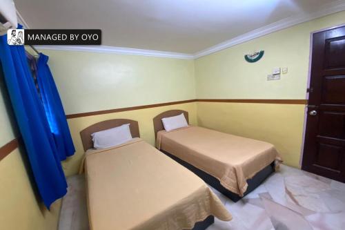 Ένα ή περισσότερα κρεβάτια σε δωμάτιο στο Hotel O Lumut Villa Inn