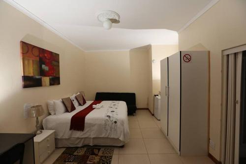 Un dormitorio con una cama y una cómoda. en The Rest Place Bed & Breakfast, en East London