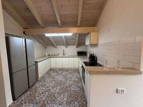 a kitchen with white cabinets and a tile floor at הזהר הצפוני in Rosh Pinna