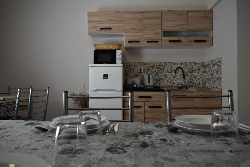 a kitchen with a table with some dishes on it at Kamilla Apartmanház Somogyudvarhely OLYANMINTOTTHONCSAKMÉGJOBB in Somogyudvarhely