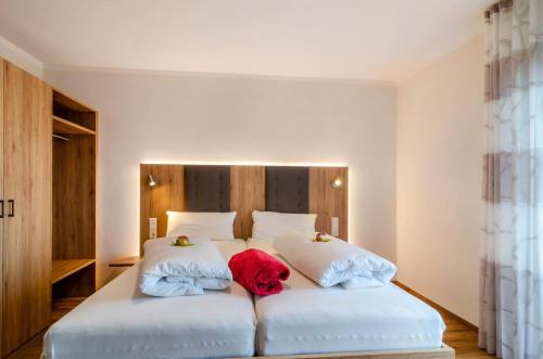 a bedroom with a large white bed with two pillows at Privatpension Eva in Hagnau