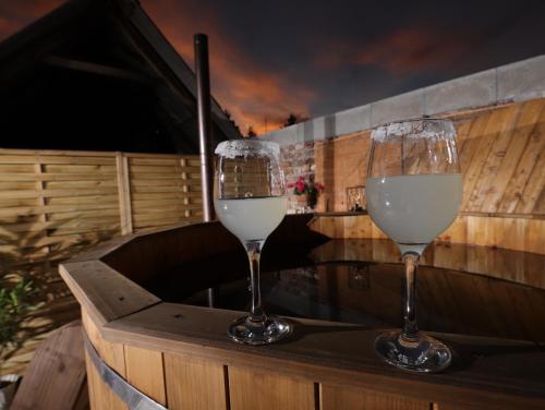 two glasses of white wine sitting on a table at Kamilla Apartmanház Somogyudvarhely OLYANMINTOTTHONCSAKMÉGJOBB in Somogyudvarhely
