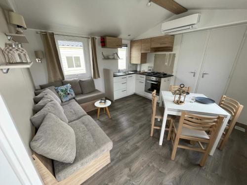 un salon et une cuisine avec un canapé et une table dans l'établissement Mobil Home Dalhias 2, à Valras-Plage