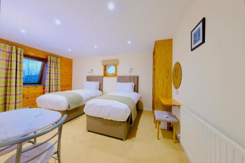 una camera d'albergo con due letti e una finestra di Suilven Cottage a Tain
