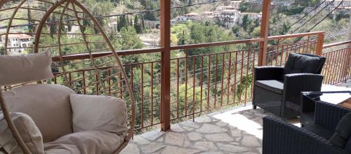 a balcony with chairs and a view of a mountain at family home in Dhimitsana