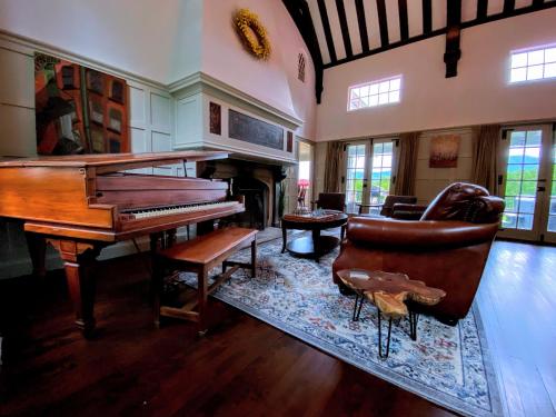 a living room with a piano and a chair at Holden Frost House in Franconia