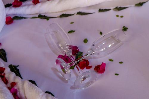 two wine glasses with flowers on a white table at Amboseli Amanya Lodge in Rift Valley