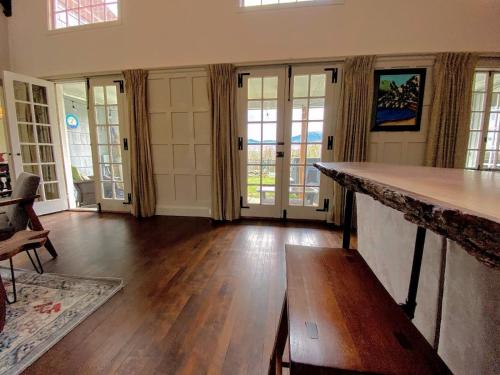 a living room with a counter and wooden floors and windows at Holden Frost House in Franconia