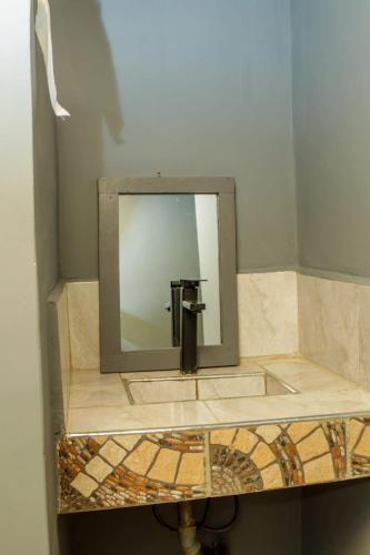 a mirror on a counter in a bathroom at Amboseli Amanya Lodge in Rift Valley