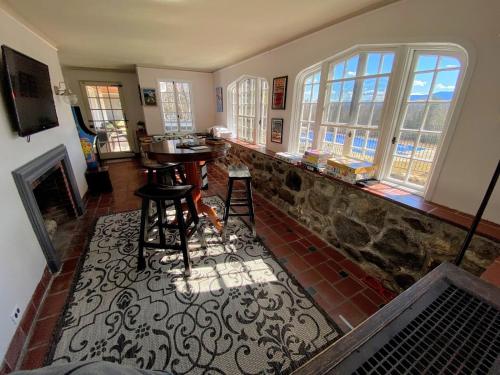 a living room with a table and a fireplace at Holden Frost House in Franconia
