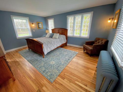 a bedroom with a bed and a chair and a couch at Holden Frost House in Franconia