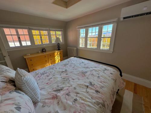 a bedroom with a bed and two windows at Holden Frost House in Franconia
