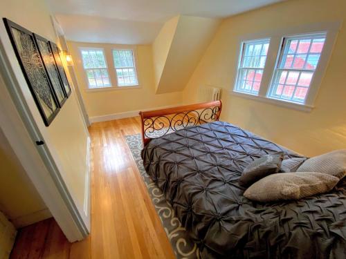 a bedroom with a bed and two windows at Holden Frost House in Franconia