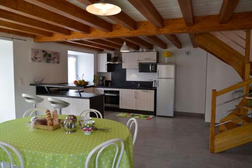 a kitchen and dining room with a table and chairs at Gîte La Maison d'Alphonse 7/8 personnes in Saint-Léger-du-Malzieu