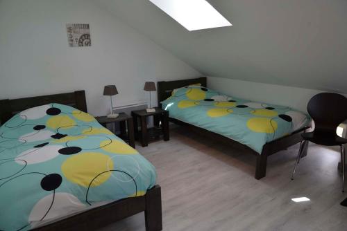 a bedroom with two beds and a table and chairs at Gîte La Maison d'Alphonse 7/8 personnes in Saint-Léger-du-Malzieu