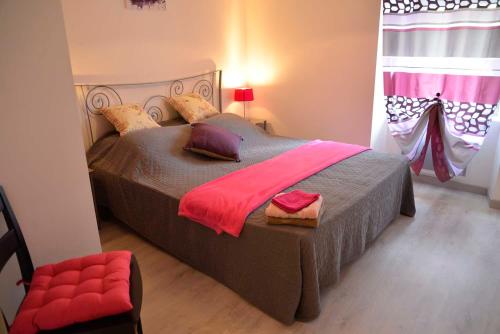 a bedroom with a large bed and a red chair at Gîte La Maison d'Alphonse 7/8 personnes in Saint-Léger-du-Malzieu