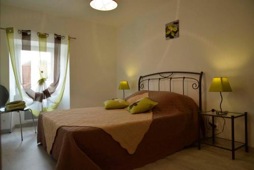 a bedroom with a bed and two lamps and a window at Gîte La Maison d'Alphonse 7/8 personnes in Saint-Léger-du-Malzieu