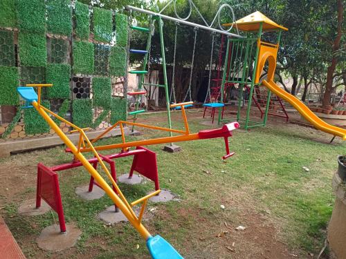 a playground with colorful playground equipment in a park at Arav Resort in Katrab