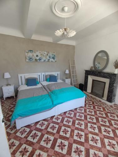 - une chambre avec un grand lit et une cheminée dans l'établissement Mas du 19eme dans le luberon, à Robion