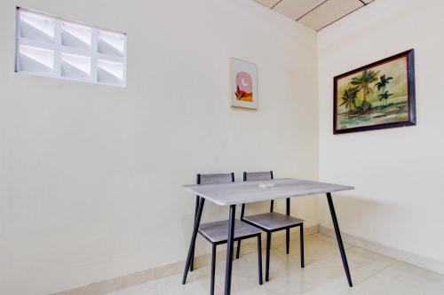 a table and two chairs in a white wall at Hotel O Homestay Ayana Syariah in Yogyakarta