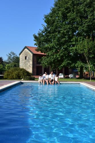 a group of people sitting in a swimming pool at QUINTA DO RIBEIRO Garden House in Lousada