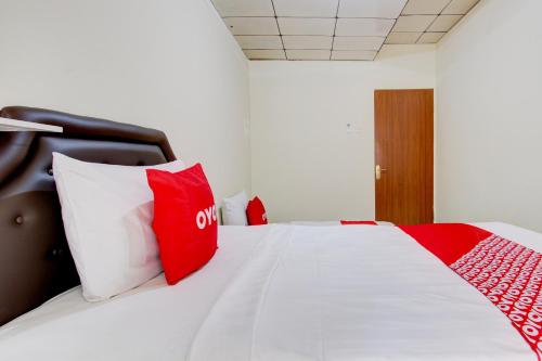 a bedroom with a bed with red and white pillows at Hotel O Homestay Ayana Syariah in Yogyakarta