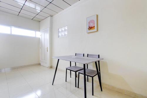 a table and two chairs in an empty room at Hotel O Homestay Ayana Syariah in Yogyakarta