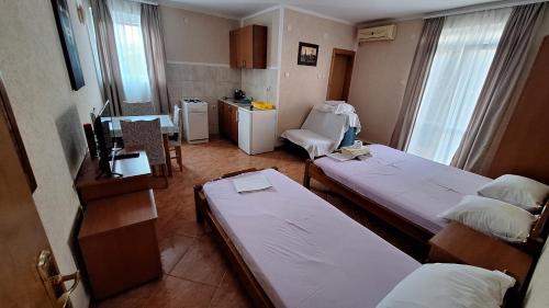 a small room with two beds and a kitchen at Ivanovic Family House Apartments in Sutomore