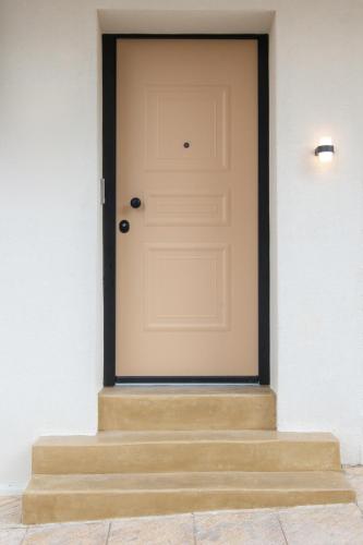 a white door on a white wall with stairs at Mazi Rooms z in Giannitsa