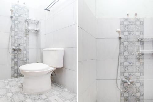 a white bathroom with a toilet and a shower at Capital O 94314 Sunny Co Living in Yogyakarta